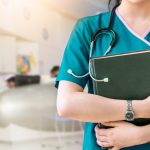 Cropped,Image,Of,Nurse,In,Purple,Uniform,Holding,Green,Book