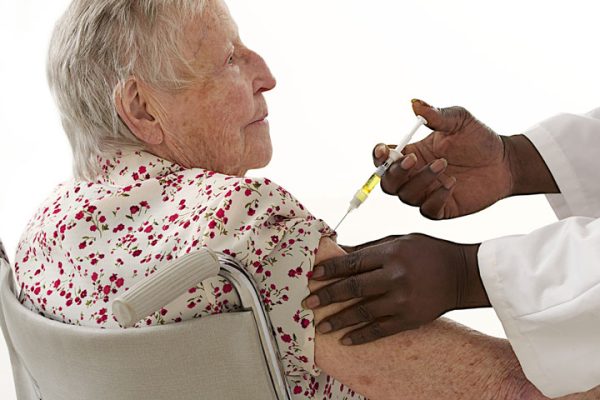NP giving older woman a flu shot