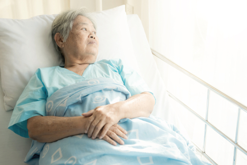 Older patient alone in hospital bed