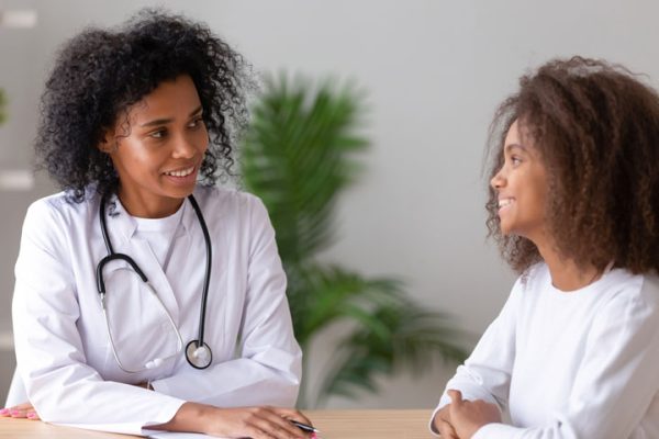 Black Nurse Practitioner With Patient