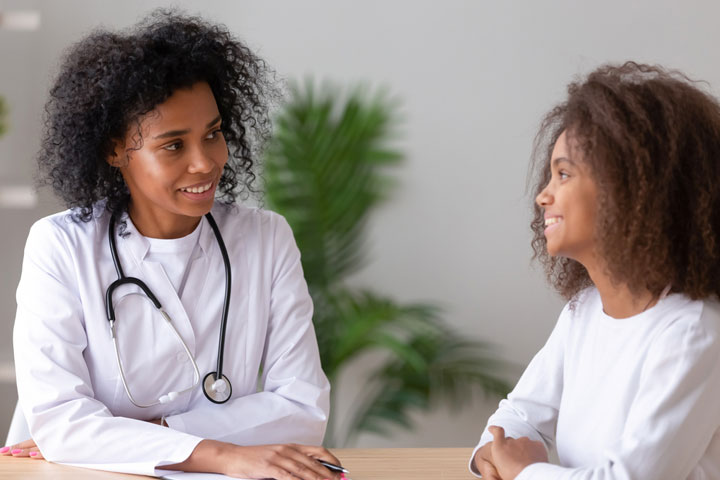 Black Nurse Practitioner With Patient