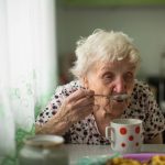 Older woman eating alone