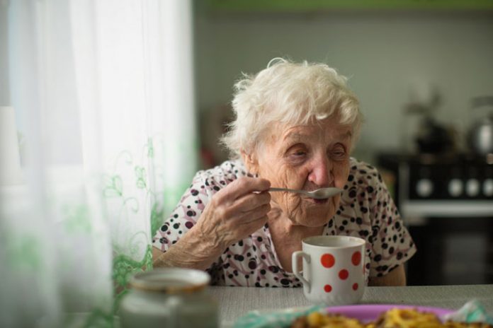 Older woman eating alone