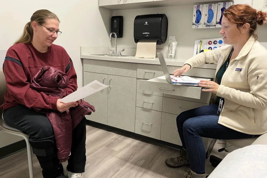 Bonnie Purk (left) meets with nurse practitioner Andrea Storjohann at the Primary Health Care clinic in Marshalltown, Iowa. Storjohann manages Purk’s treatment with Suboxone, a medication that dampens cravings for opioids and prevents withdrawal symptoms. (TONY LEYS / KHN)