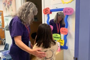 Nurse Practitioner and school nurse Jodi Bobbitt helps a youngster at William Ramsay Elementary in Alexandria, Virginia. (Colleen DeGuzman/KFF Health News)