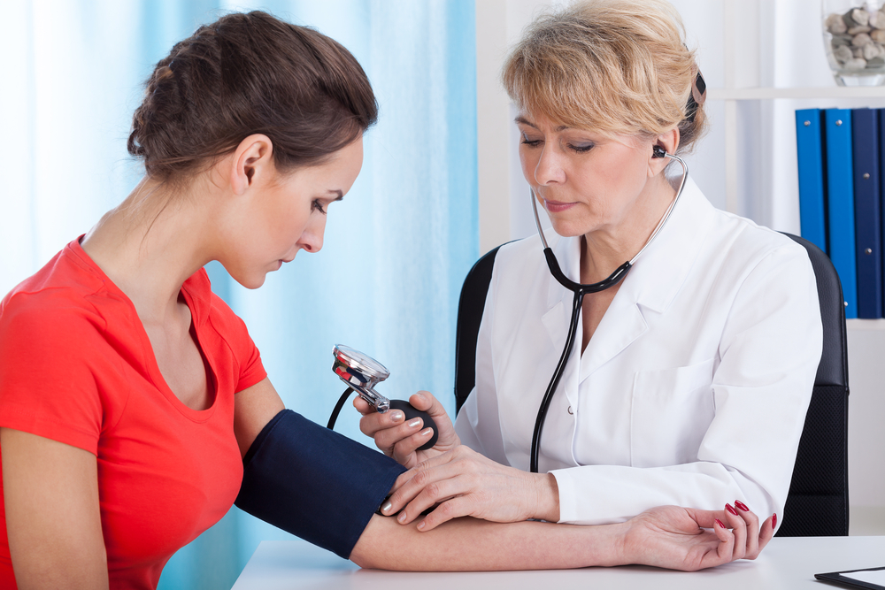 NP taking patient's blood pressure reading